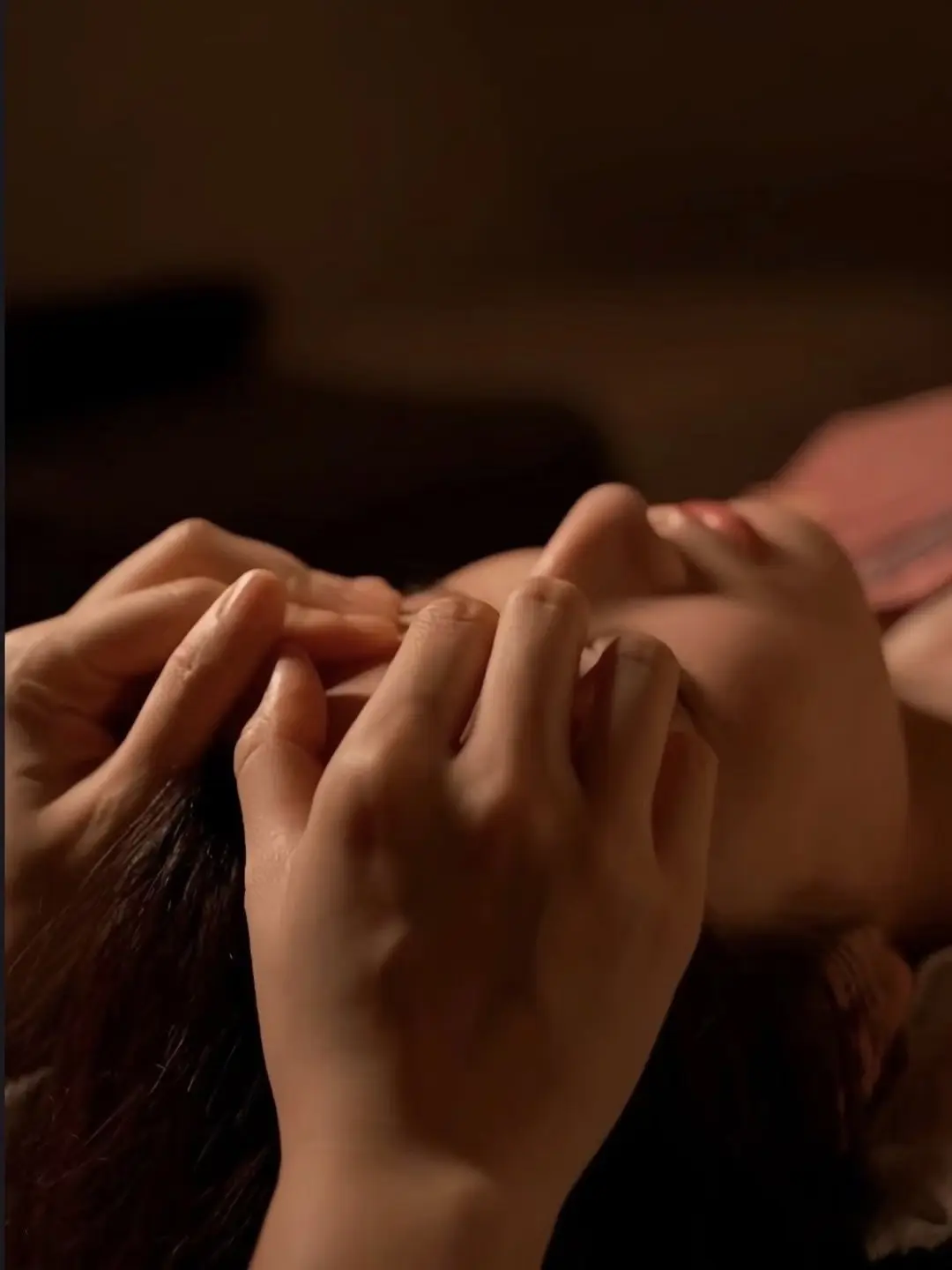 A therapist's hands at the temples during a scalp treatment near Blaine, MN